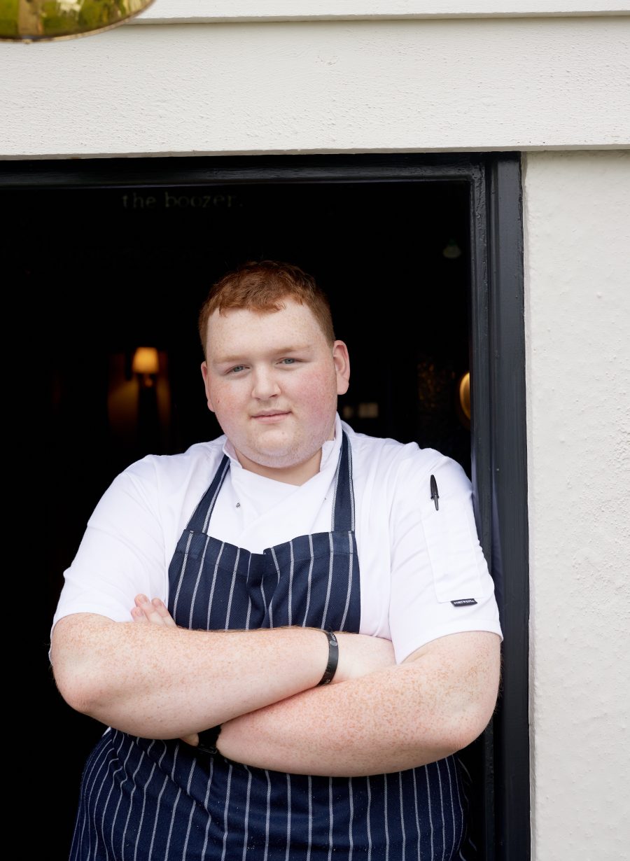 staff member posing in front of pub building
